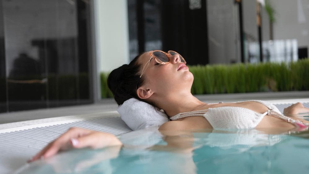 High ticket affiliate marketer relaxing in hot tub after receiving commission