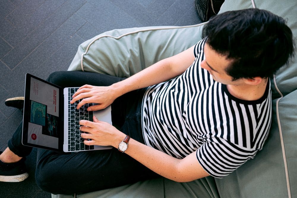 A person looking at a laptop with a graph showing the importance of monitoring and adjusting your SEO plan