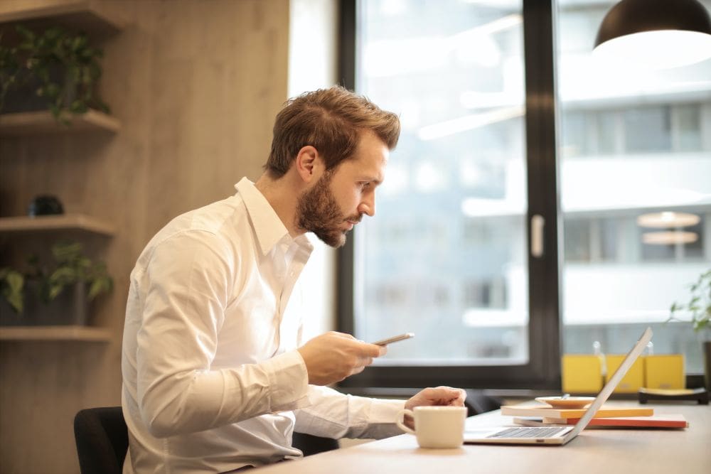 A person working on a laptop, comparing affiliate marketing and dropshipping